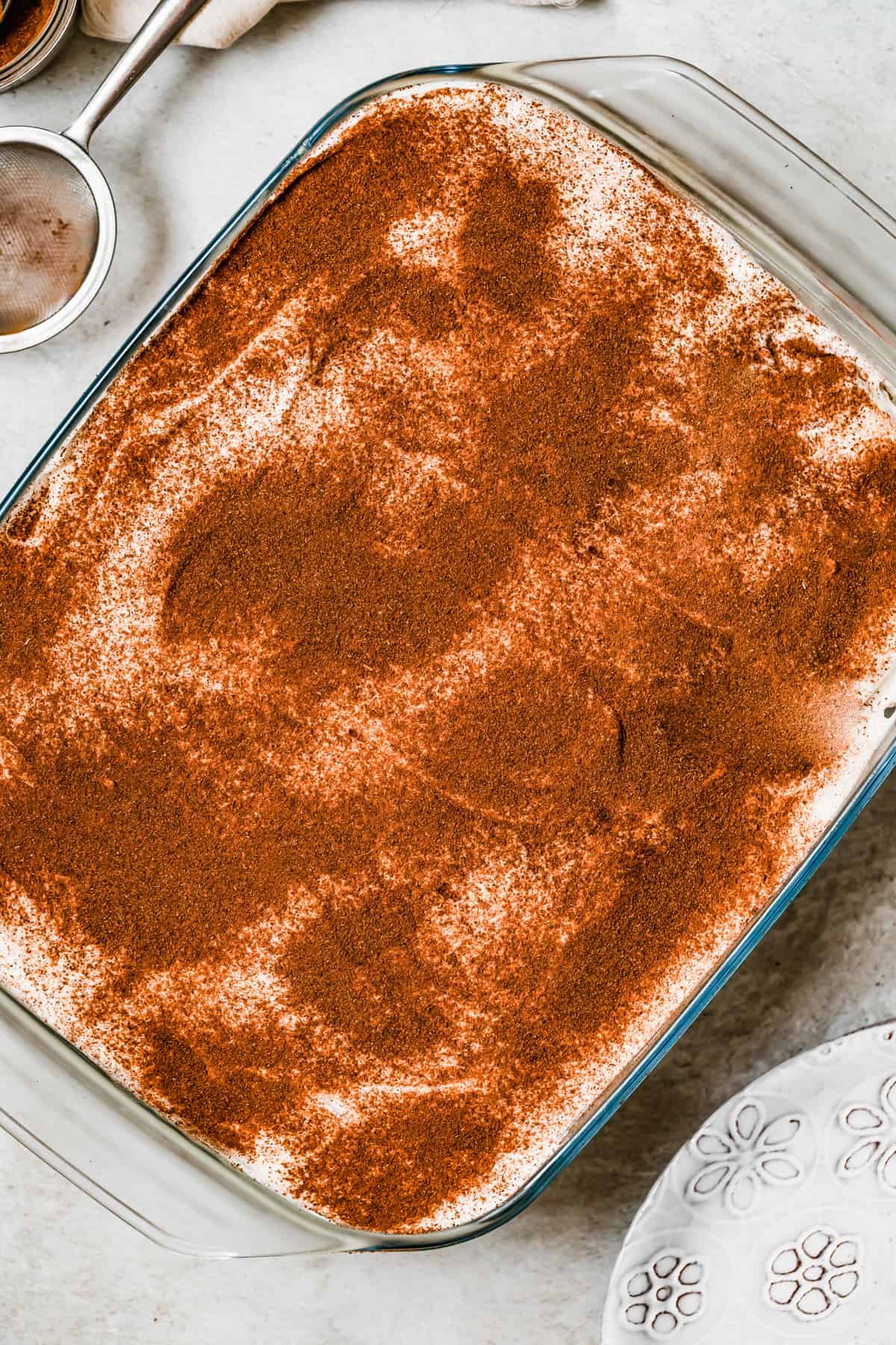 Cinnamon topped tres leches cake in a baking pan.