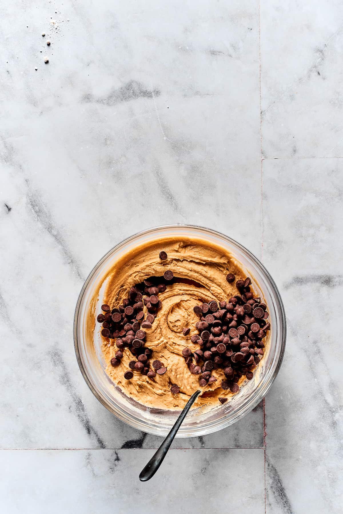 Adding chocolate chips to cookie dough.