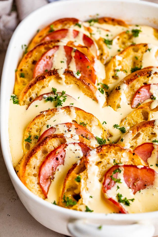 overhead shot of baked eggs benedict casserole topped with hollandaise sauce.