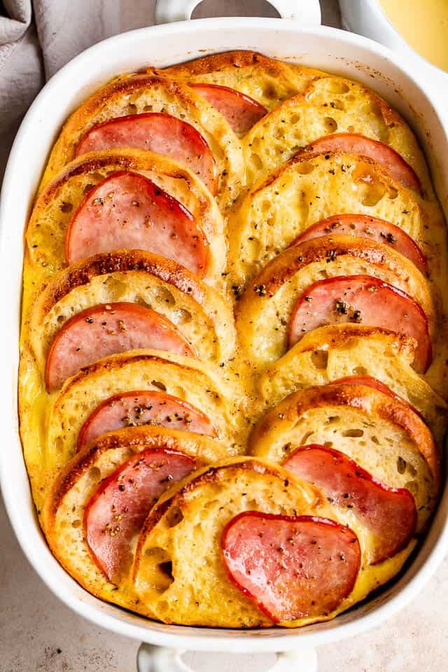 overhead shot of eggs benedict casserole in a white baking dish
