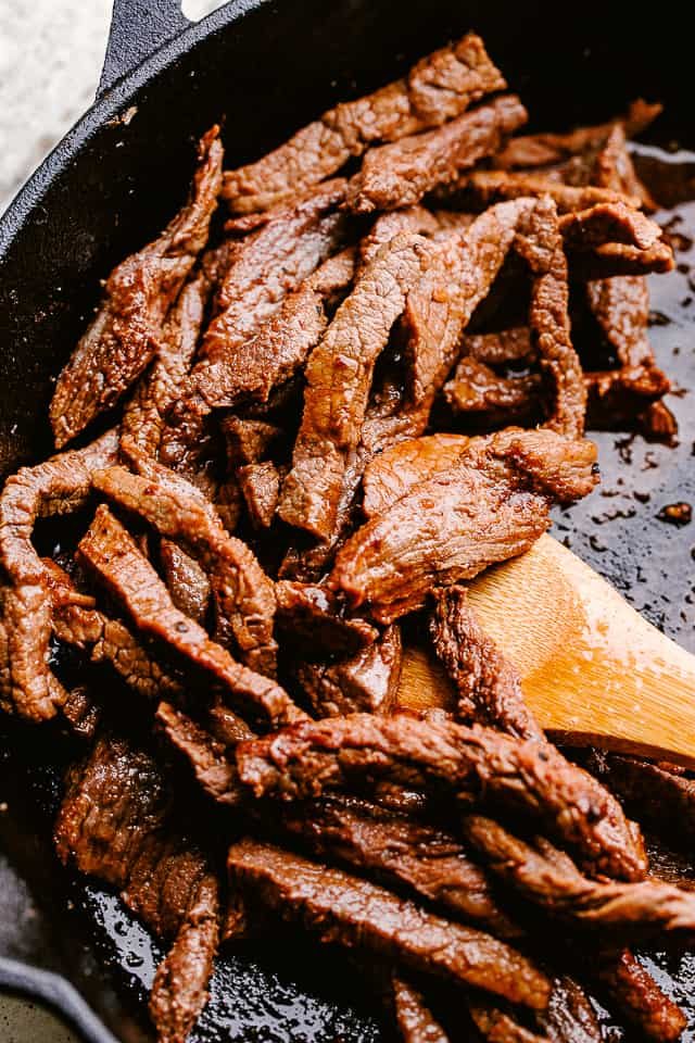 Searing flank steak in a skillet.