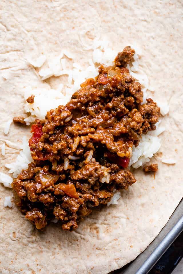flour tortilla topped with rice and beef