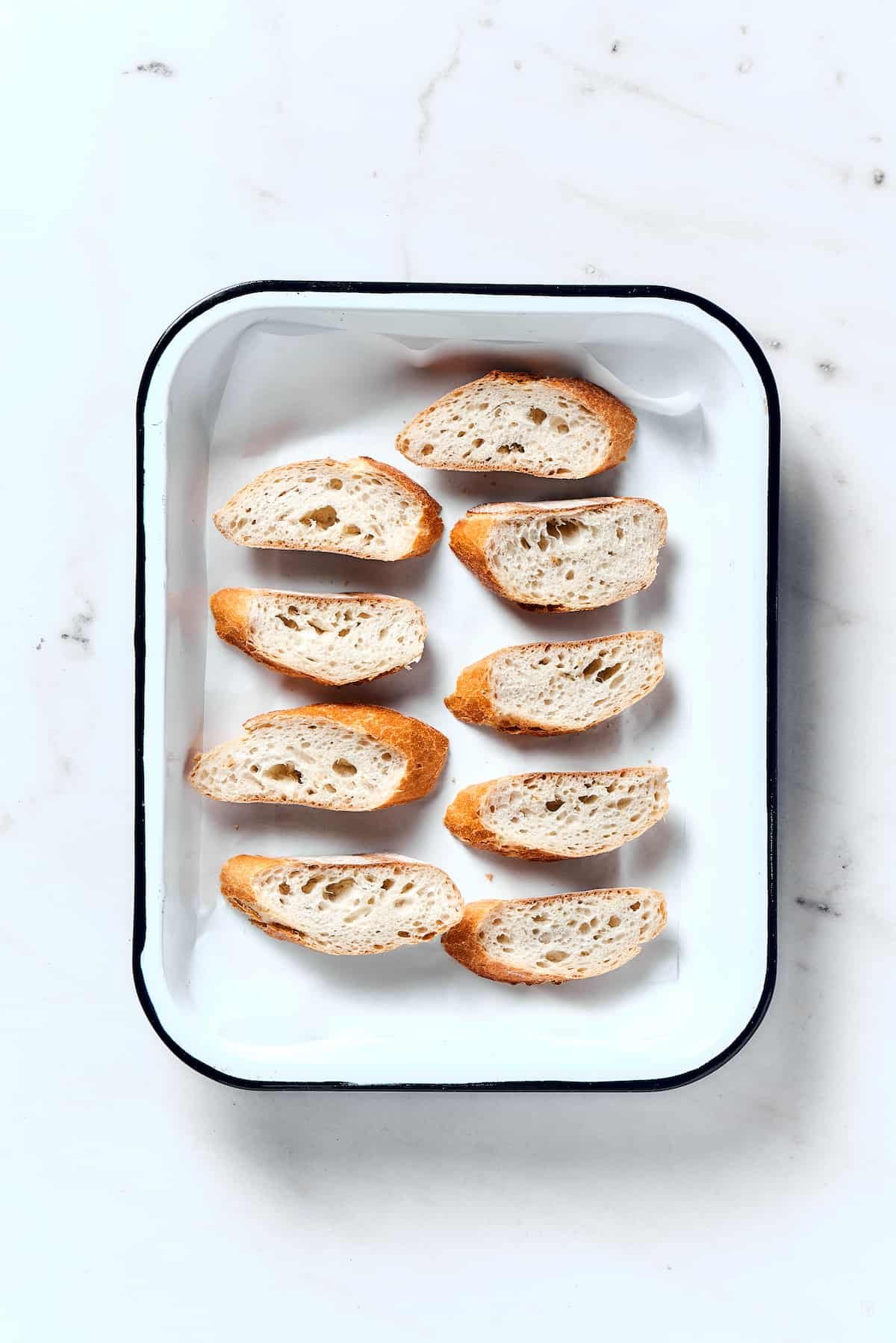 Baguette slices on a baking sheet.