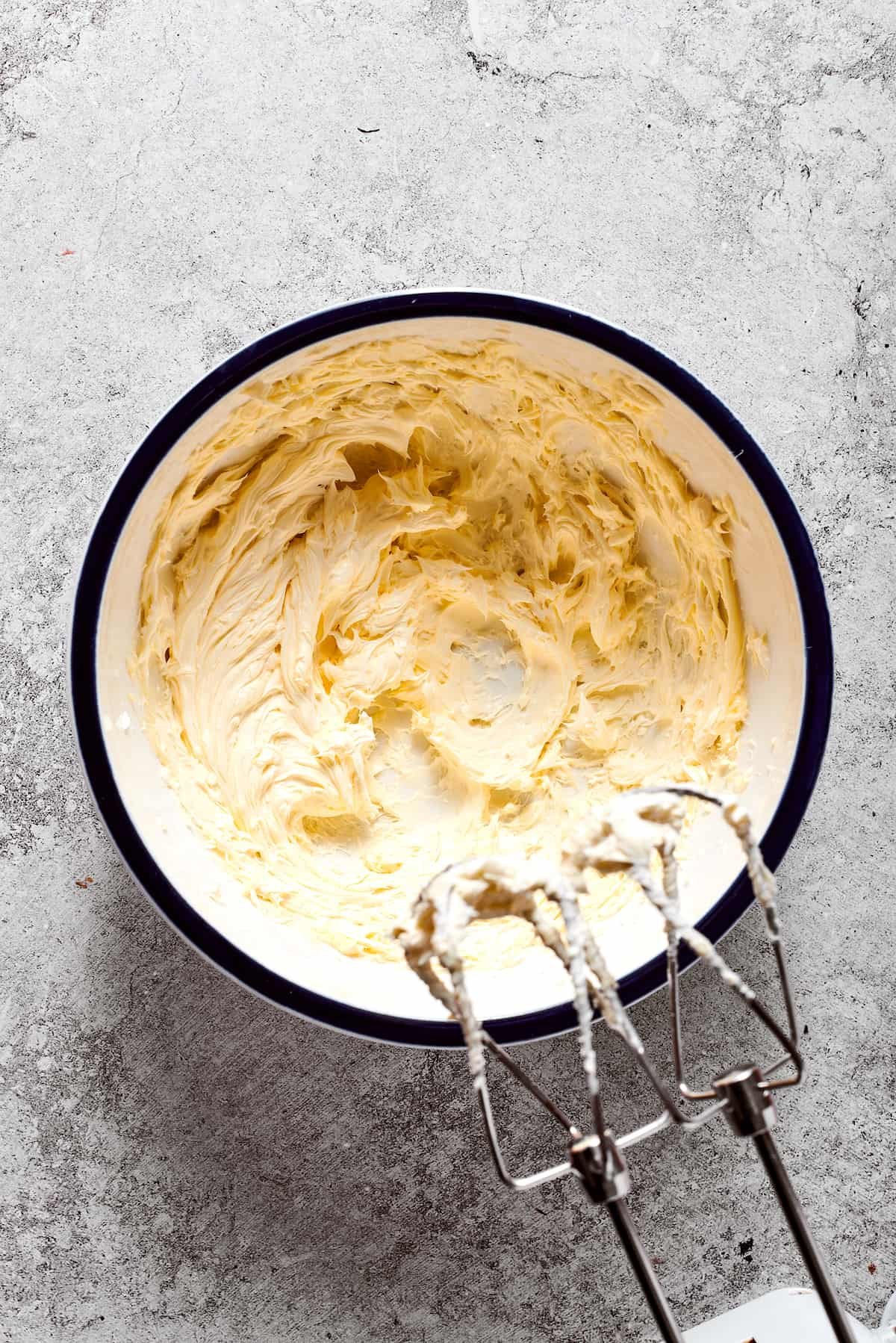 Butter is whipped into fluffiness with a hand mixer.