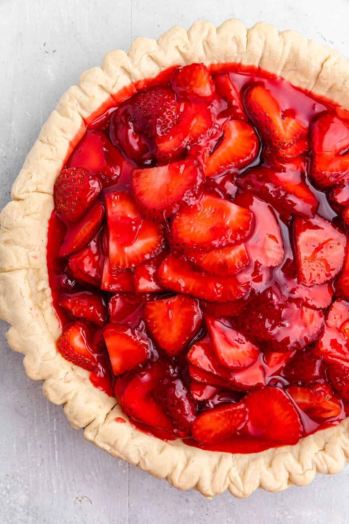 A par-baked pie shell filled with sliced strawberries and strawberry jello filling.