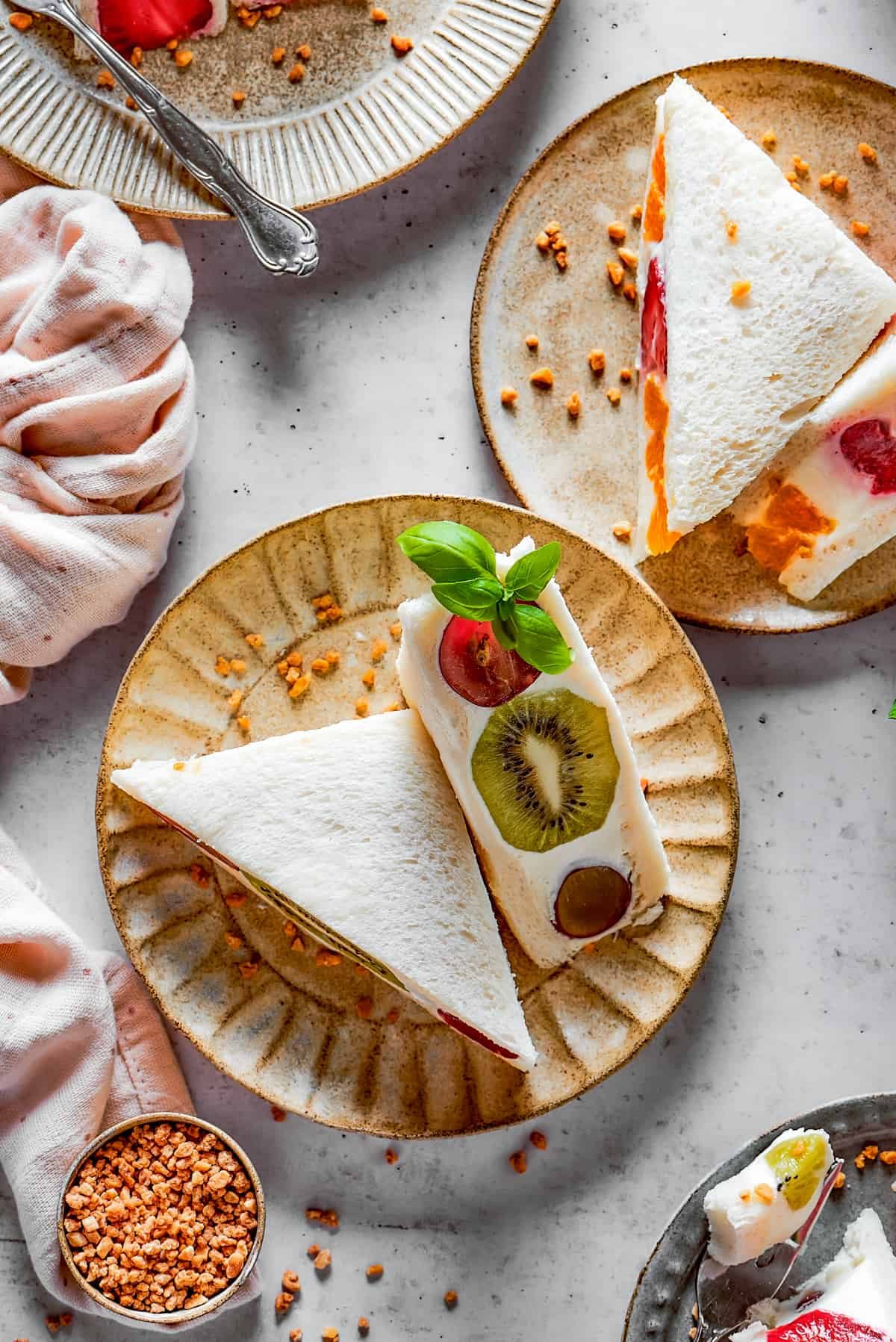 Fruit sandwiches on small, decorative plates.