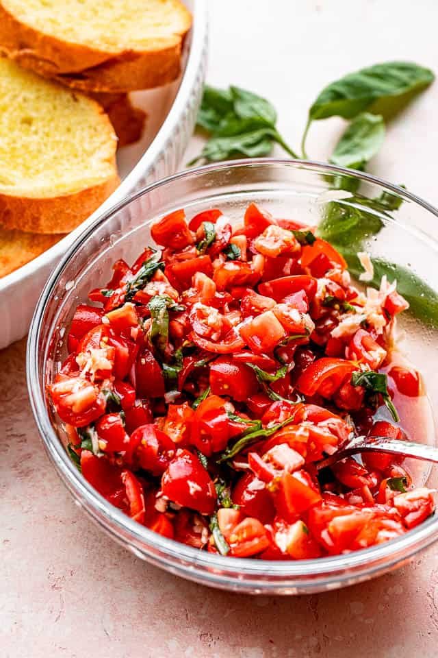 tomato salad in a salad bowl set next to toasted garlic bread