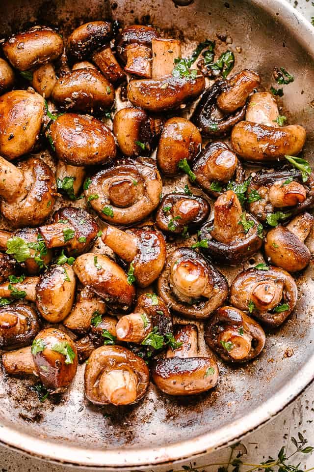 Garlic butter mushrooms in a skillet.