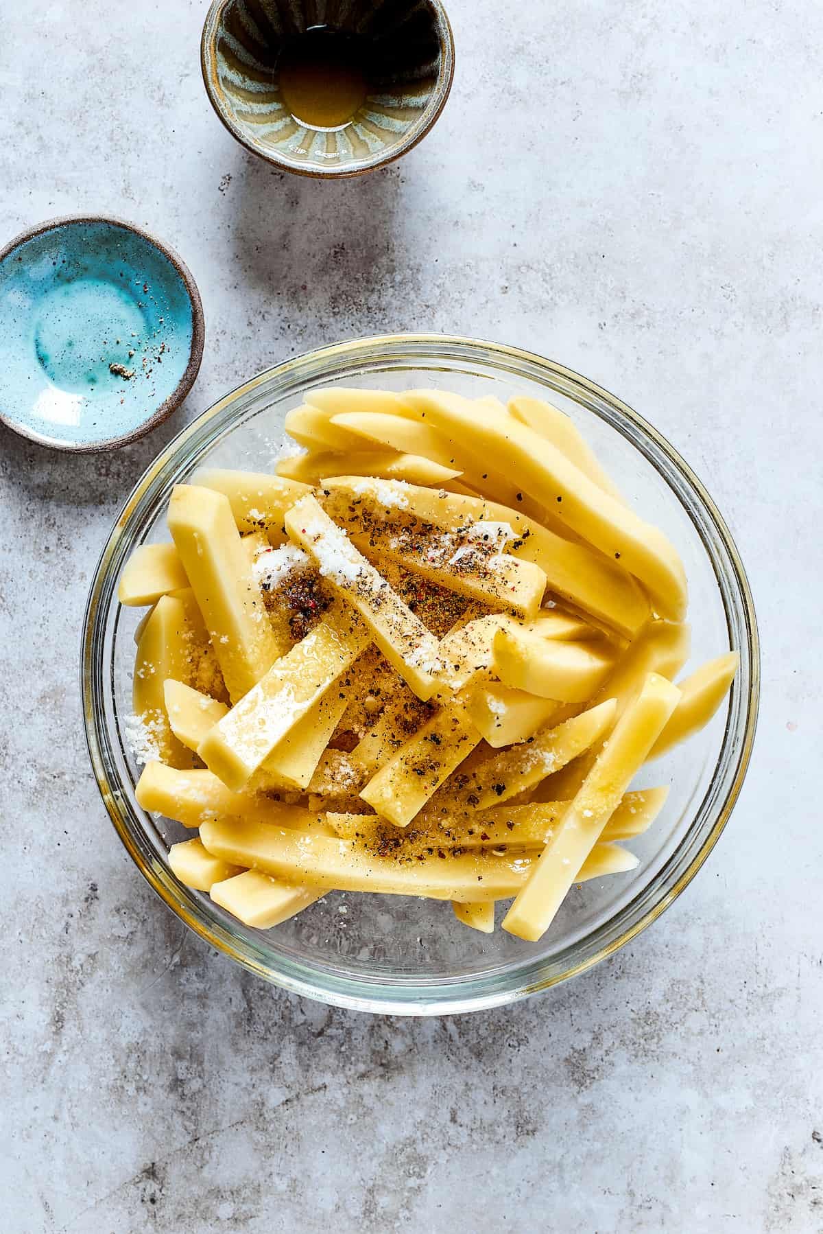 Seasoning the uncooked fries.