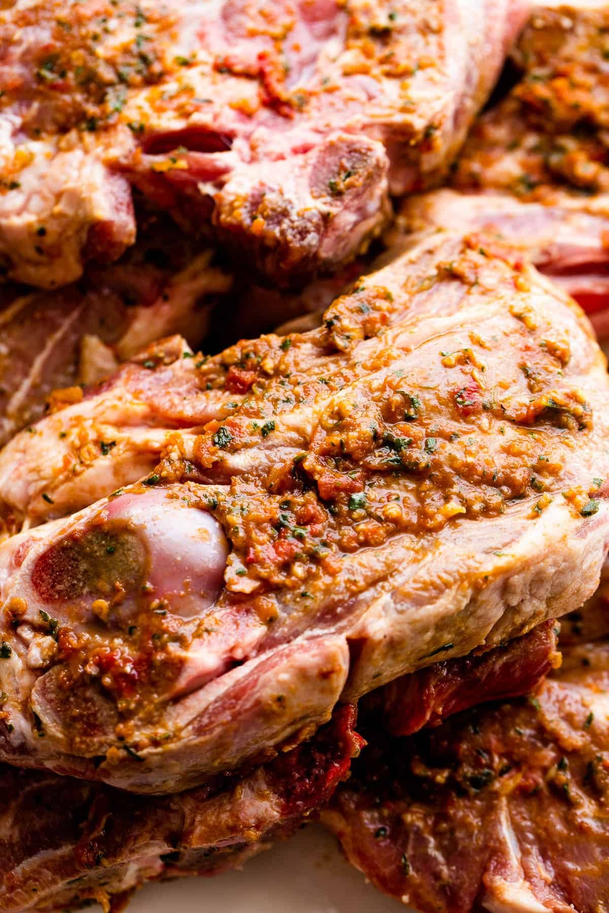 raw shoulder lamb chops topped with sundried tomatoes marinade