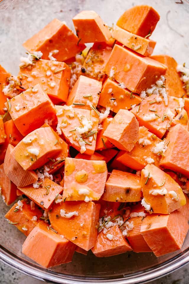 overhead shot of chopped raw sweet potatoes in a mixing bowl