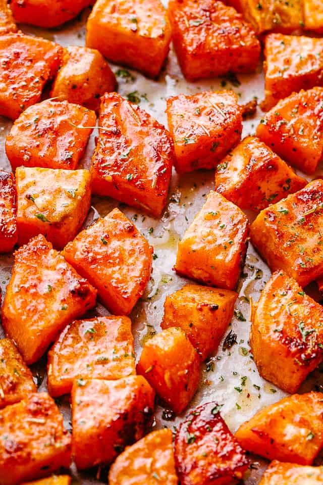 overhead shot of chopped sweet potatoes on parchment paper