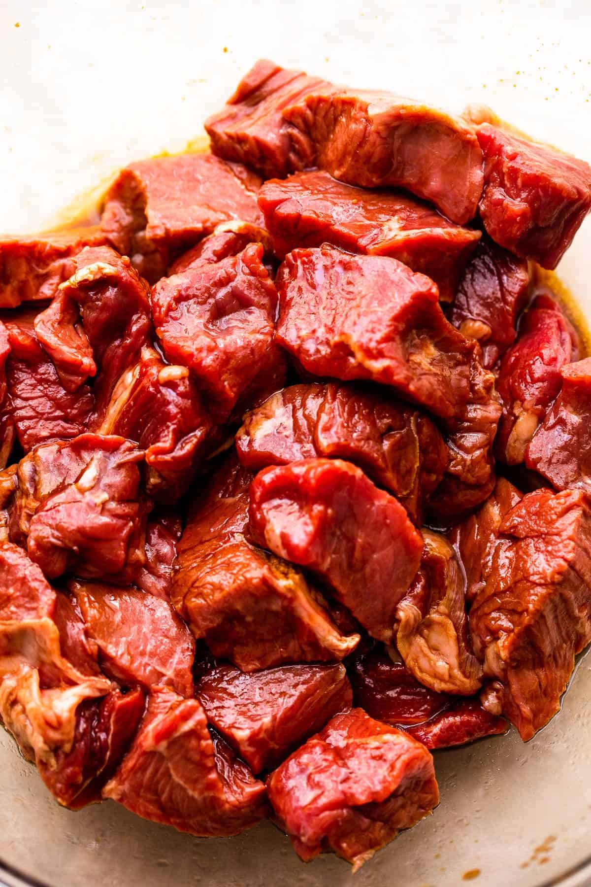 marinating steak bites in a glass bowl