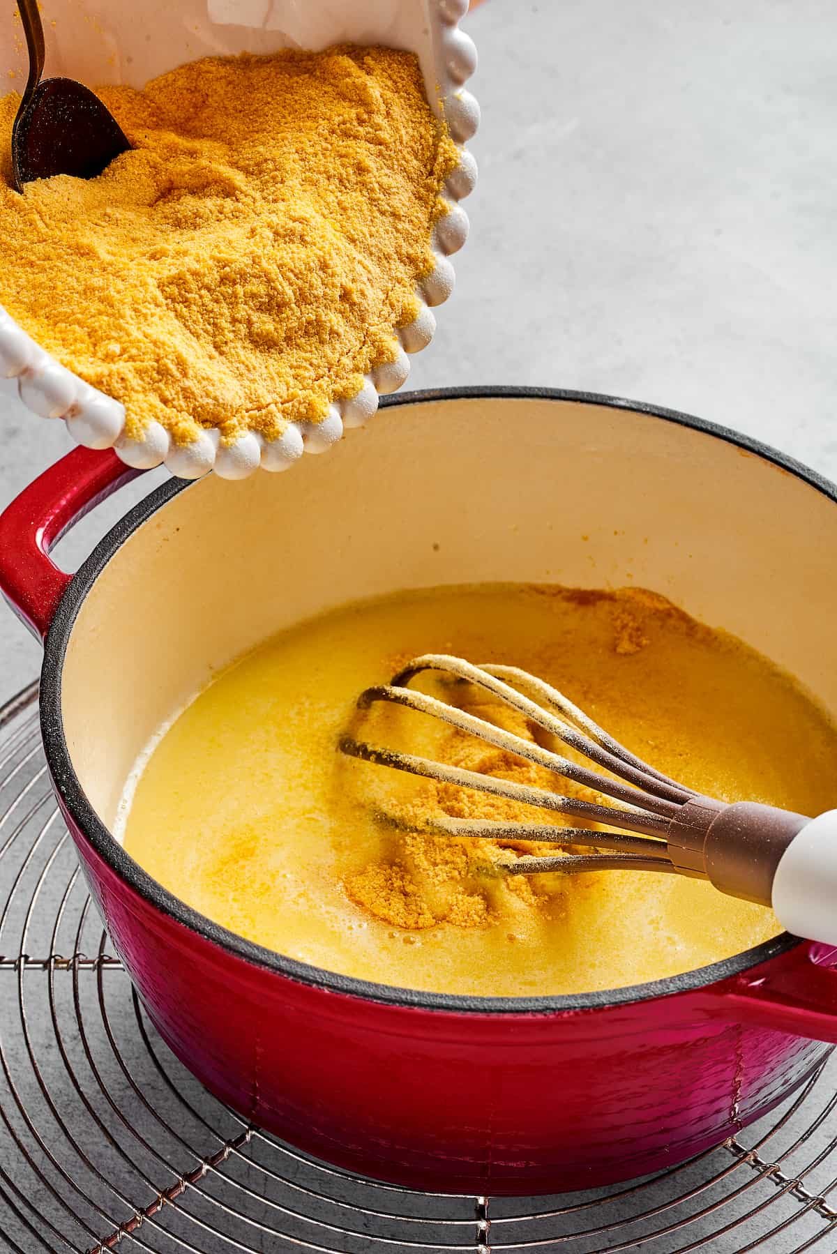 Semolina being stirred into a pot of liquid.