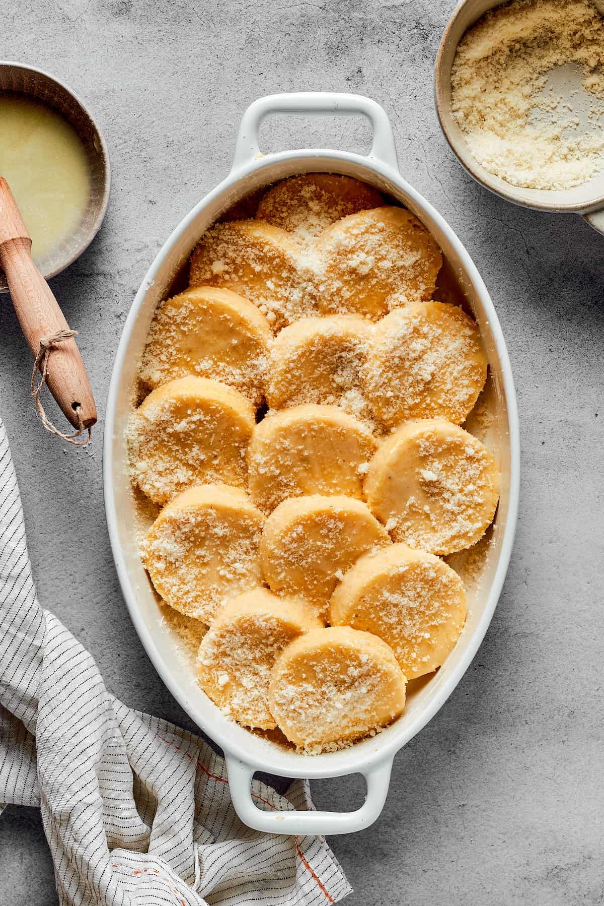 An oval baking dish of gnocchi dusted with parmesan cheese.