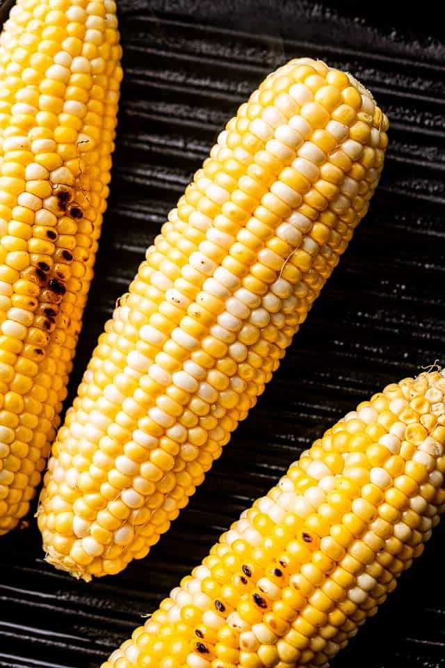 3 ear cobs of corn on the grill