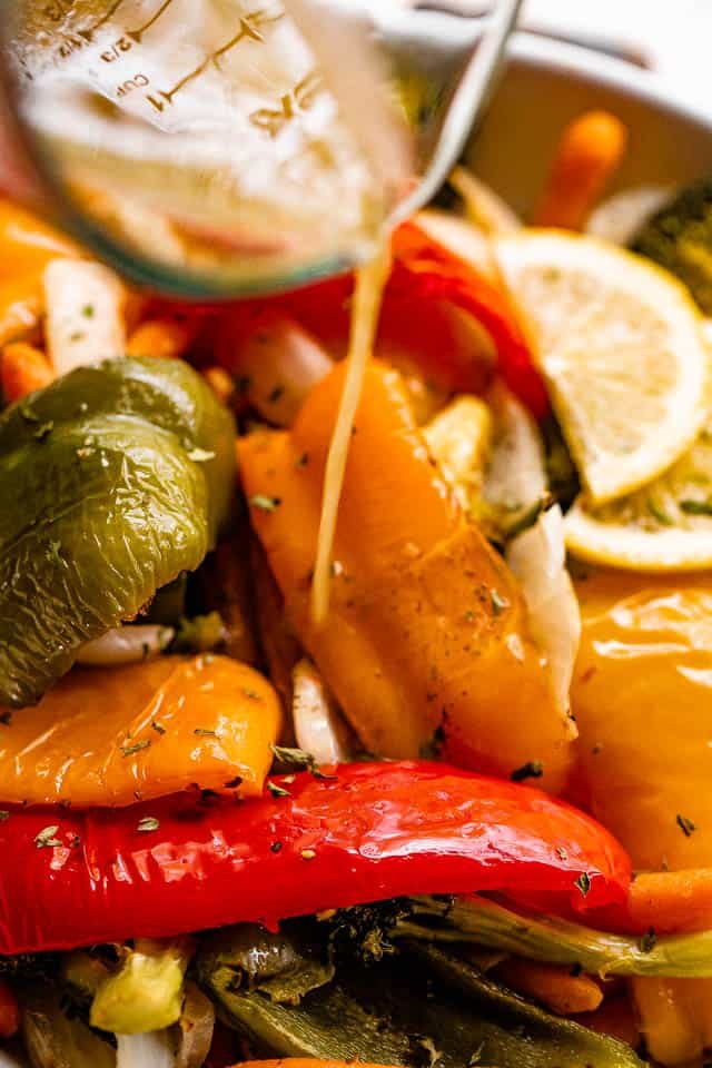 pouring lemon vinaigrette over grilled bell peppers