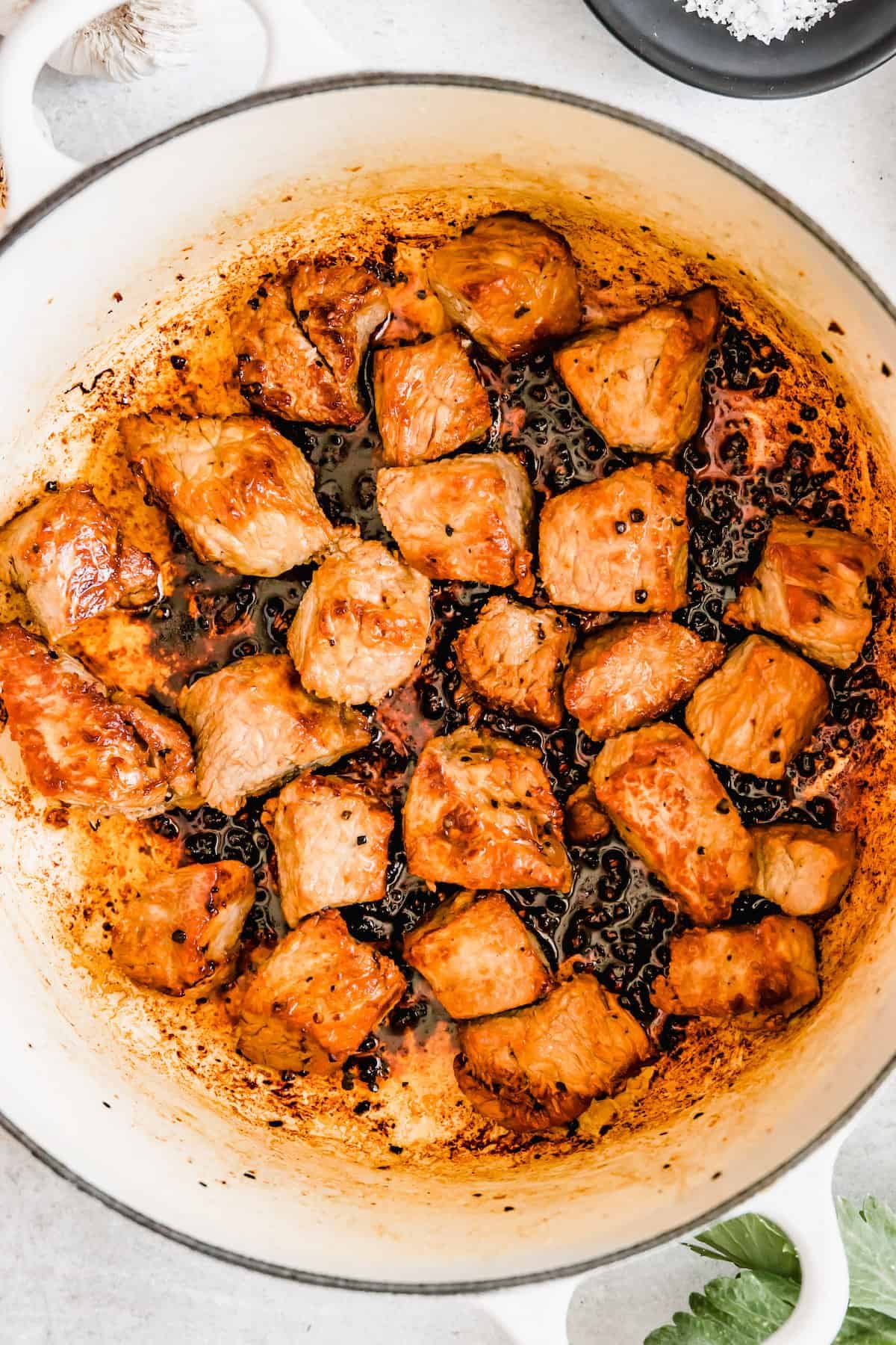 Chunks of beef cooking in a pot.