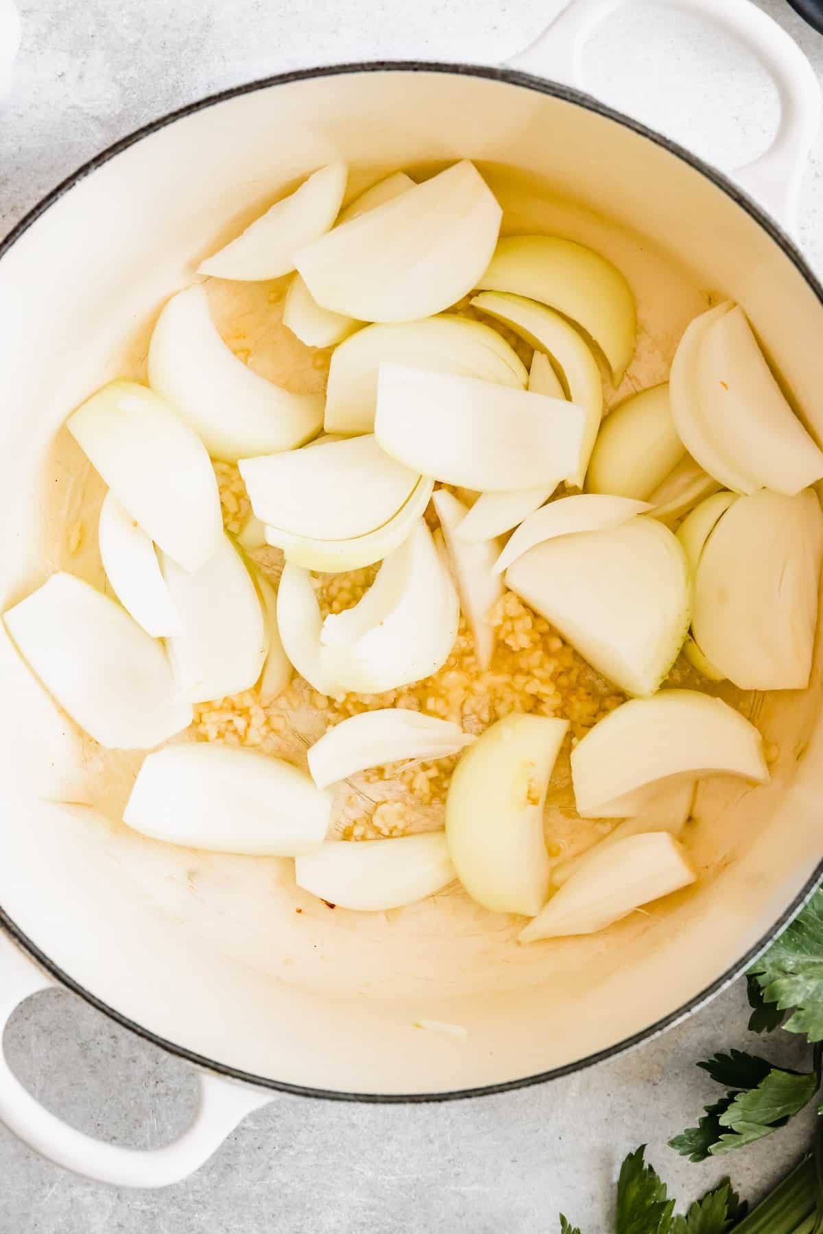 Chopped onions and garlic cooking in a pan.