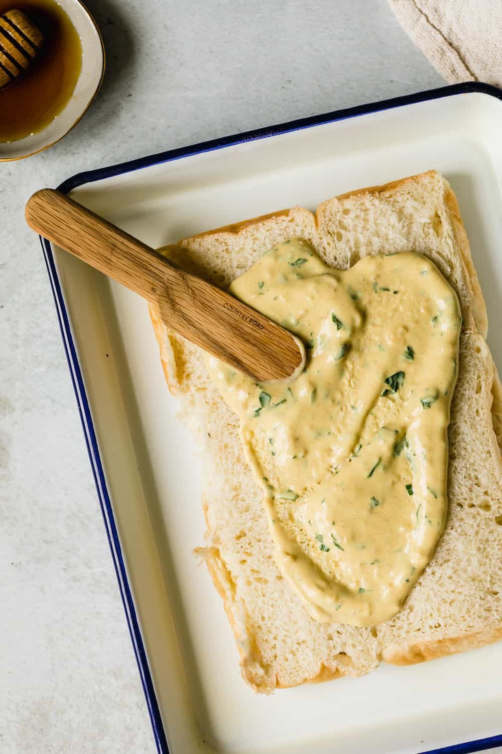 The Honey-Dijon Sauce Spread Over the Bottoms of the Hawaiian Rolls