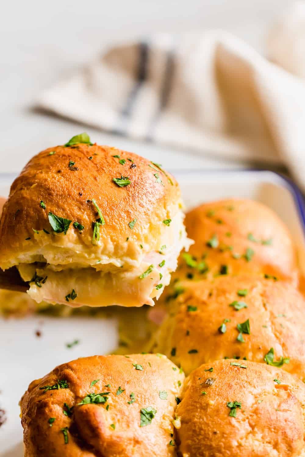 A Close-Up Shot of a Hot Ham and Cheese Sandwich Topped with Parsley