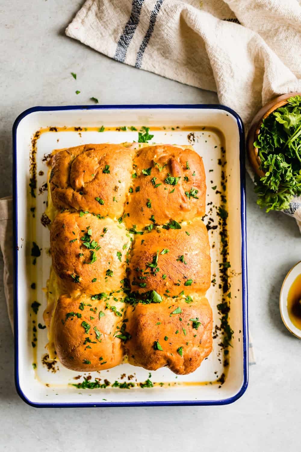 Six Ham and Cheese Sandwiches Topped with Butter and Parsley