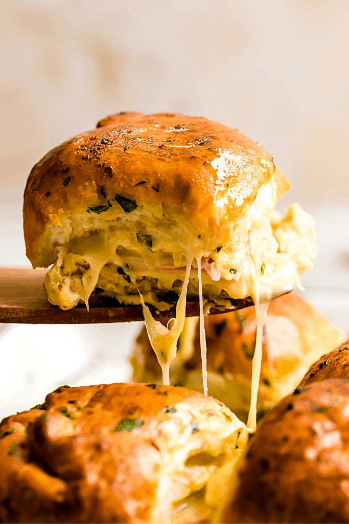 A Hot Ham and Cheese Slider on a Wooden Serving Spatula