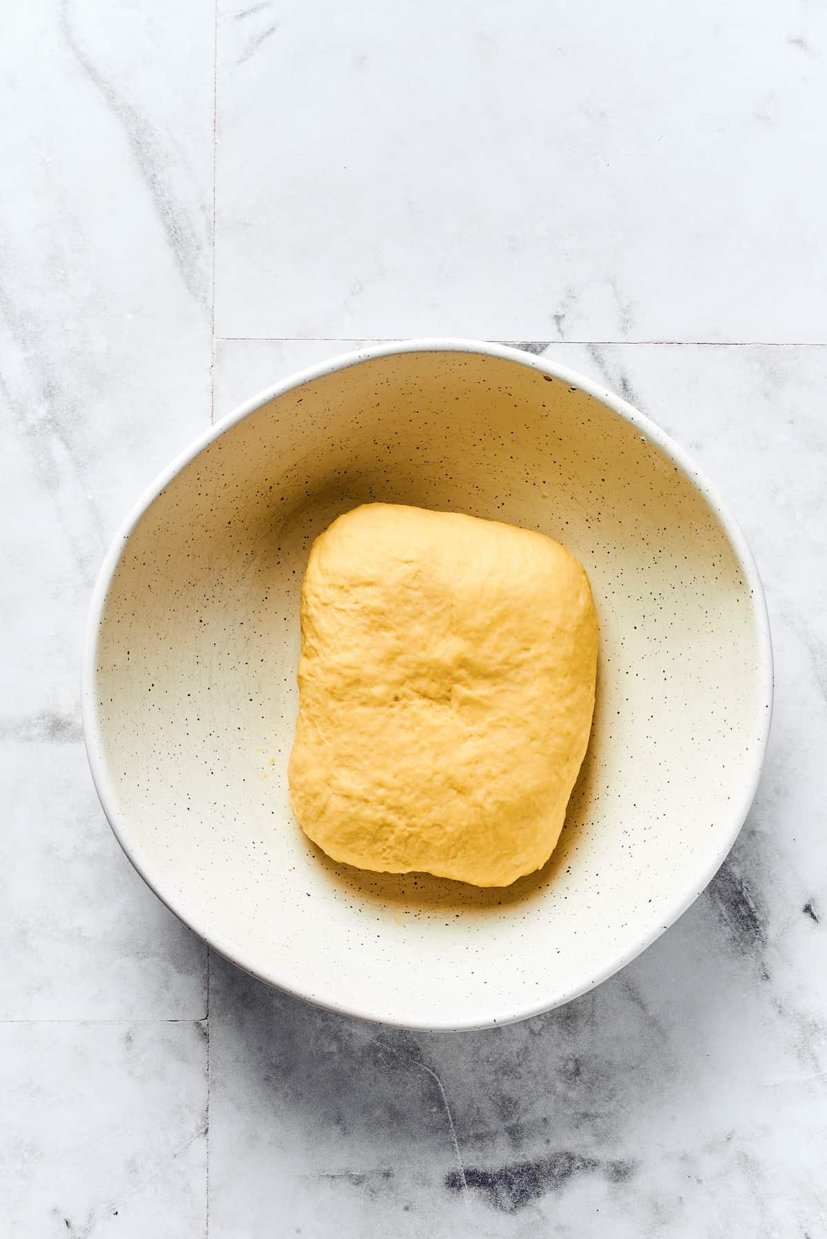 A small rectangle of dough in a clean bowl.