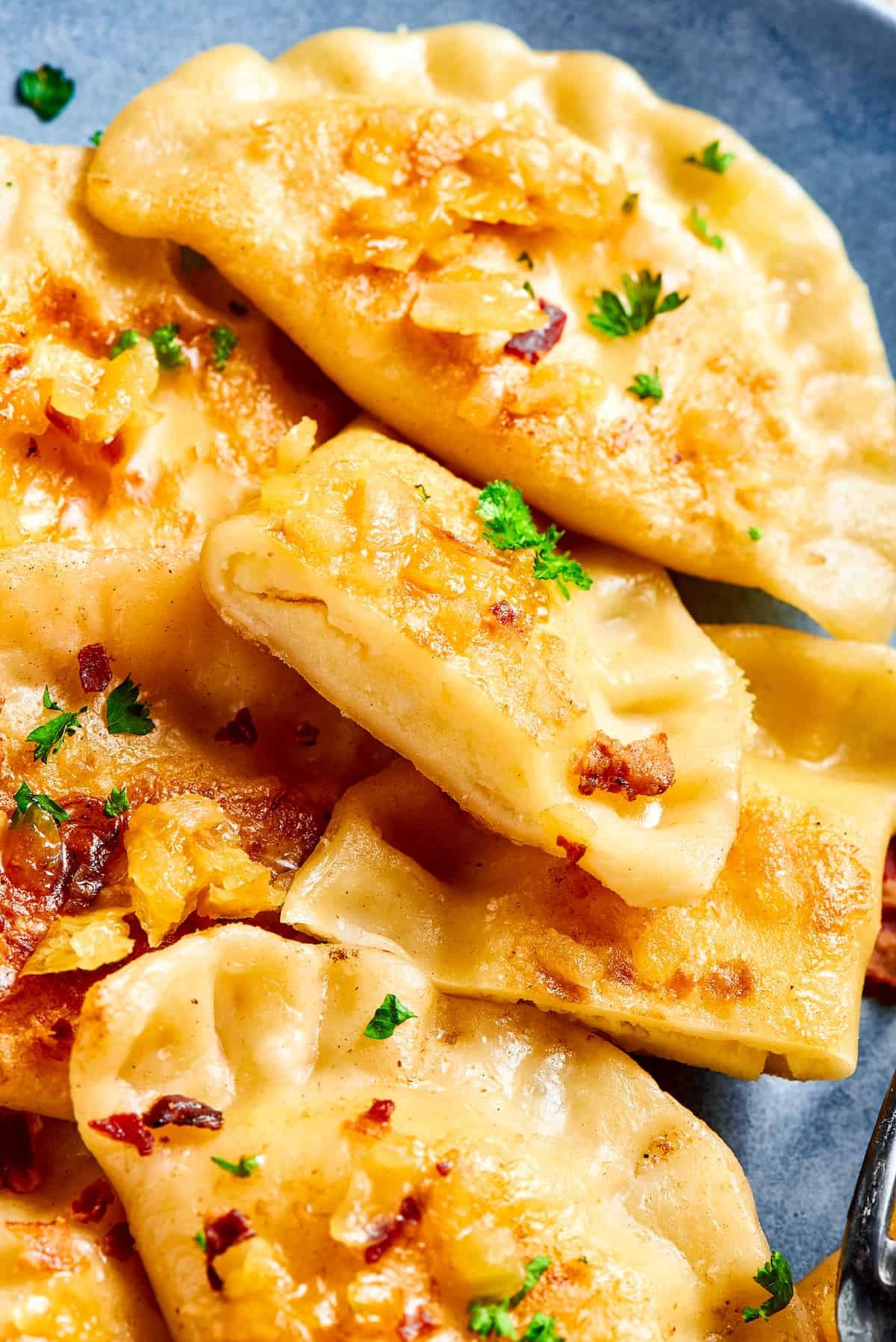 Traditional potato dumplings on a plate, with onions and bacon.