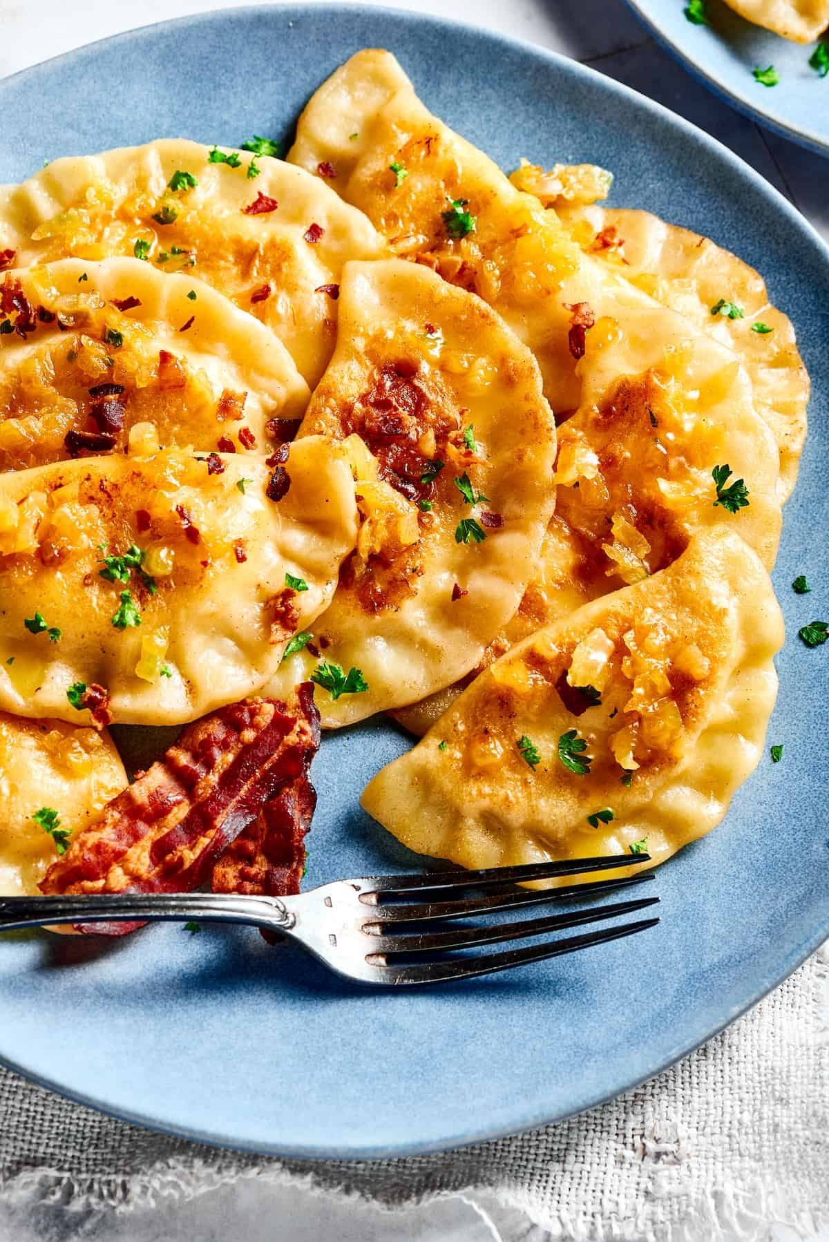 Bacon and onion topped pierogi ruskie.