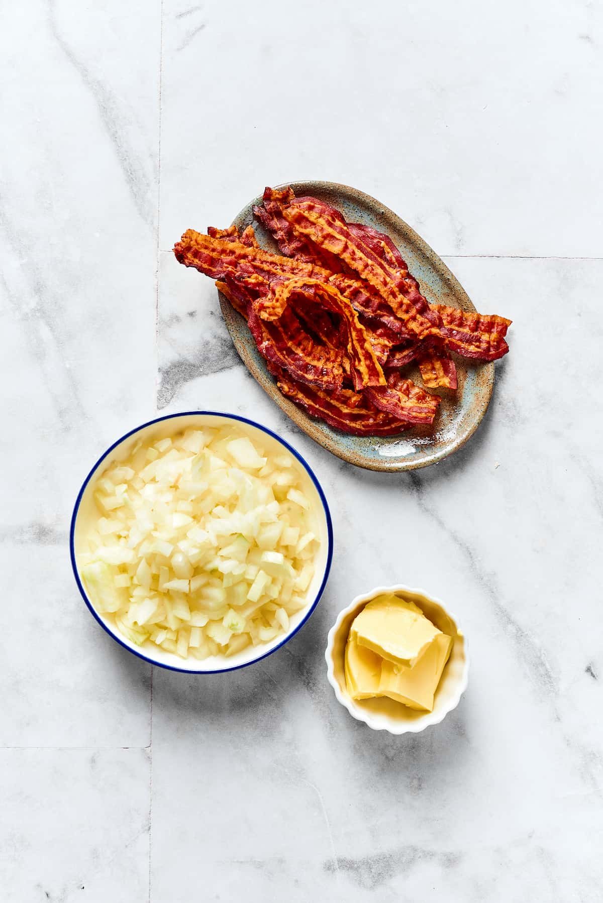 From top: Crisply-cooked bacon, chopped onion, and butter.
