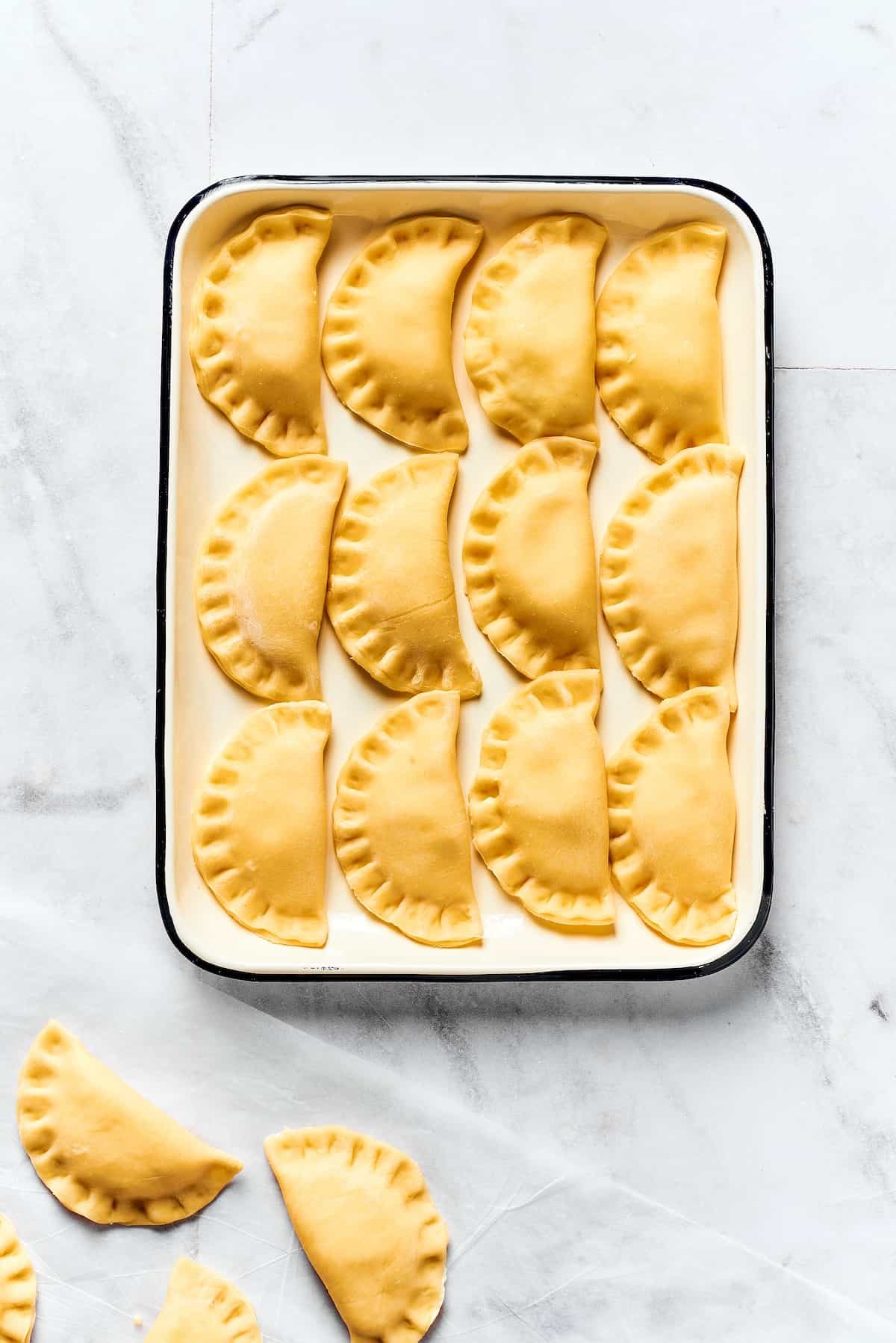 A tray of uncooked pierogies.