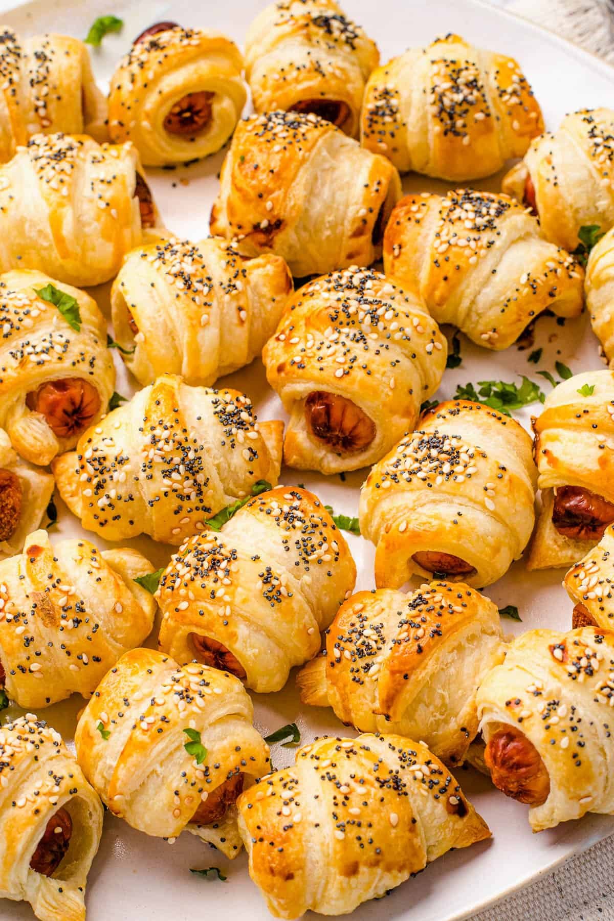 Close up shot of crescent roll hot dogs sprinkled with sesame and poppy seeds.