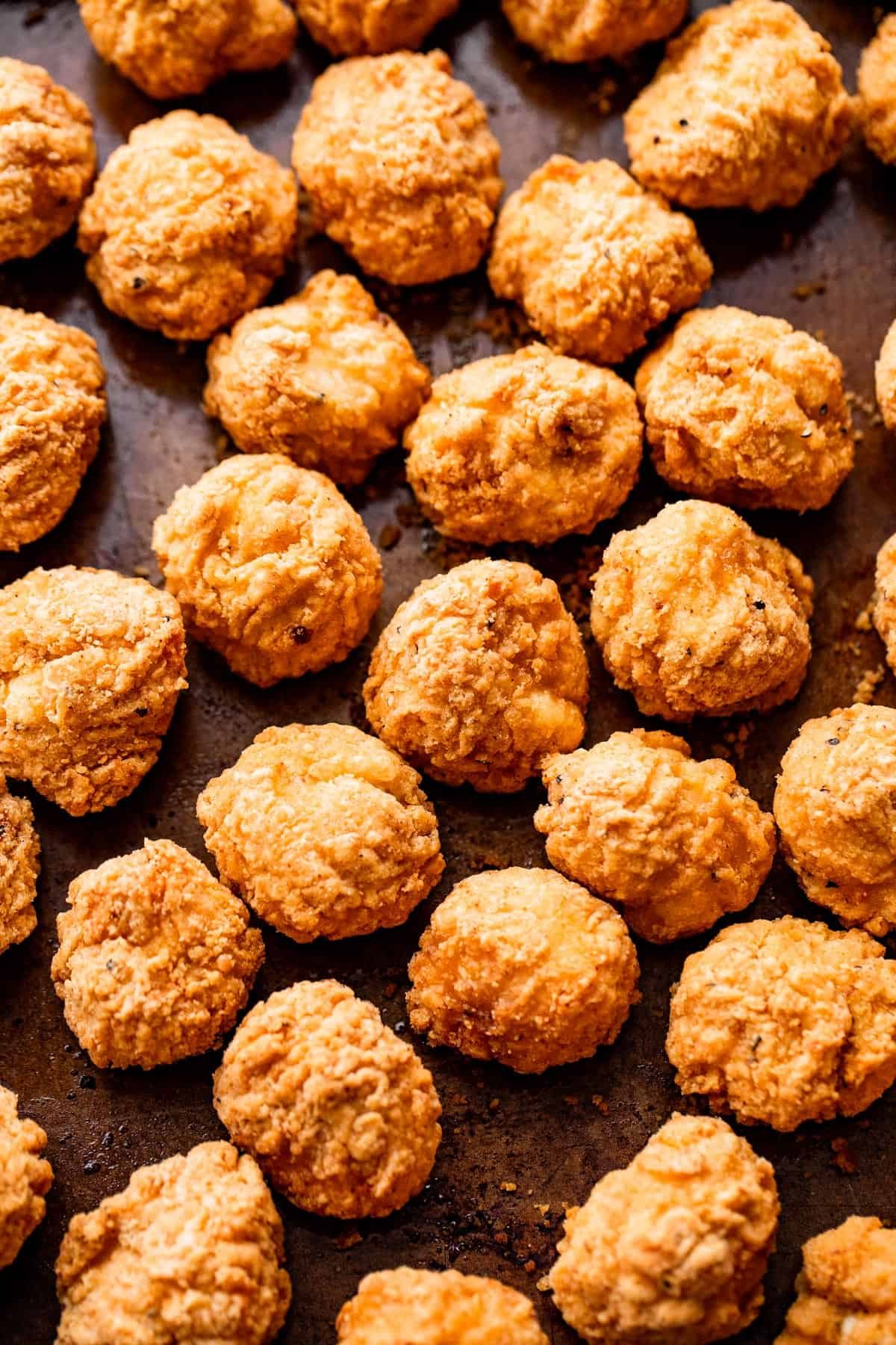 popcorn chicken arranged on a sheet pan
