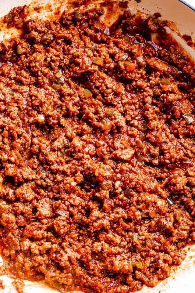 Ground beef in a skillet mixed with ketchup and brown sugar.