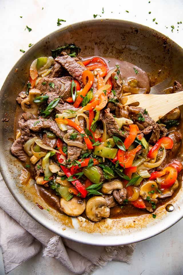 overhead wide shot of a skillet with stir fried beef and vegetables