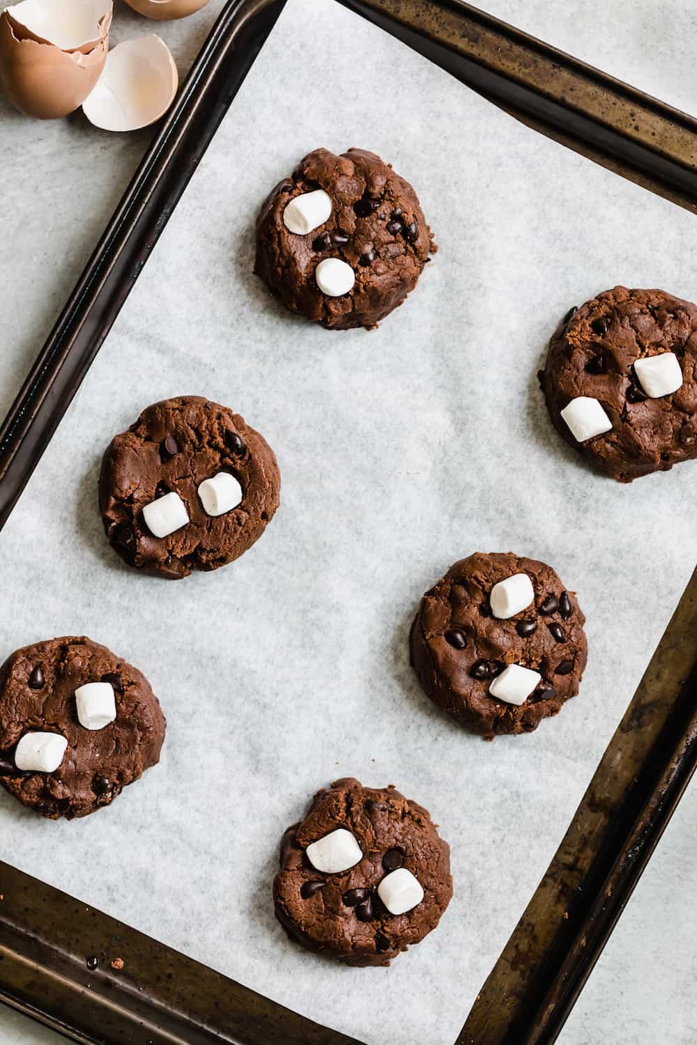 Six Dough Balls on a Lined Pan, Topped with Chocolate Chips & Marshmallows