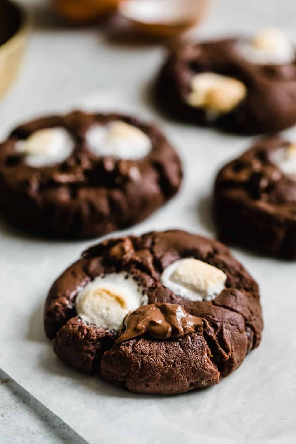 Four Chocolate Marshmallow Cookies on a Sheet of Parchment