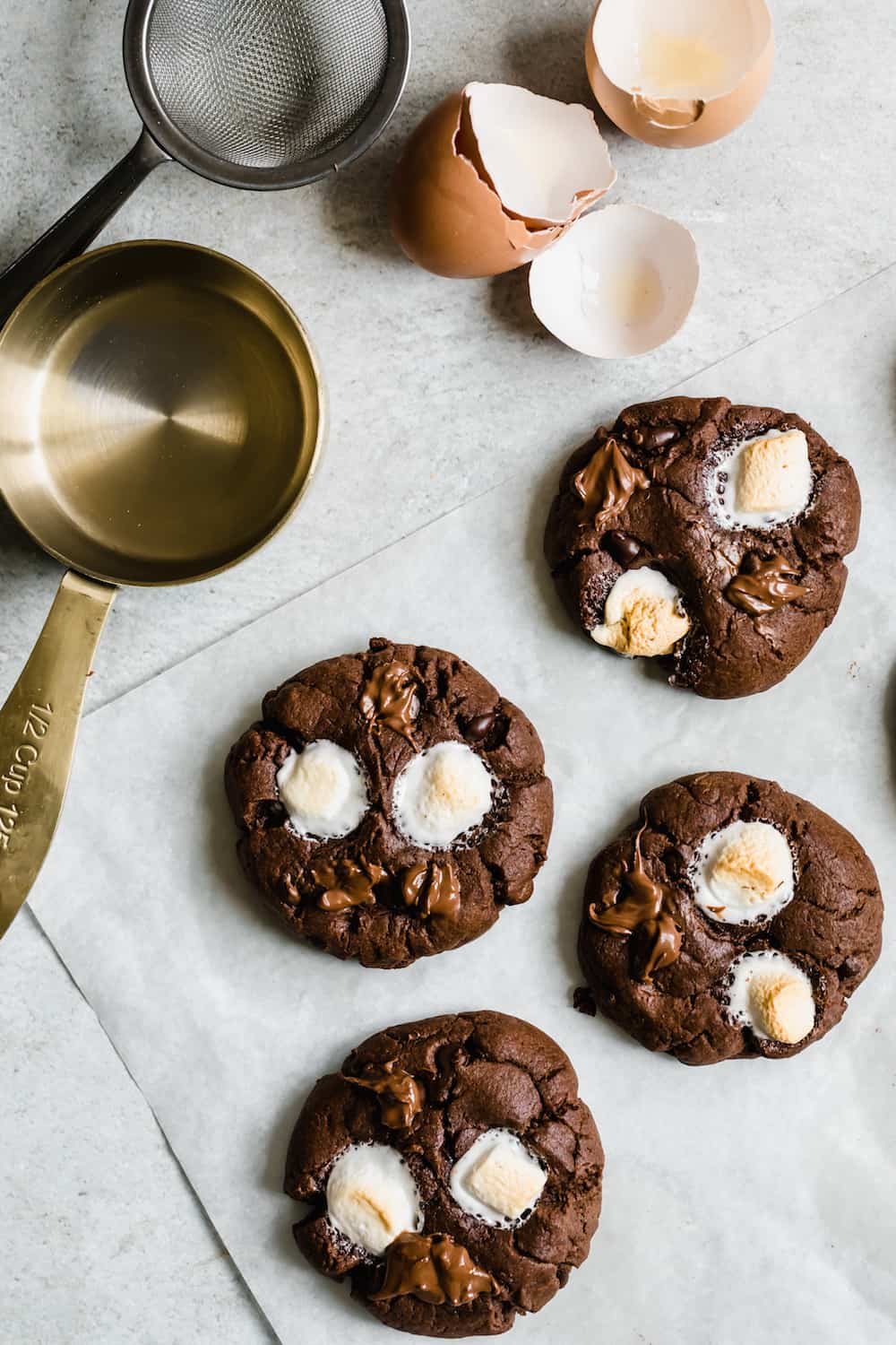 Four Hot Chocolate Sugar Cookies, a Measuring Cup and a Mesh Sieve