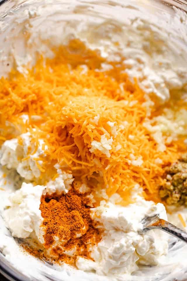 cream cheese, seasonings, and shredded cheese in a mixing bowl