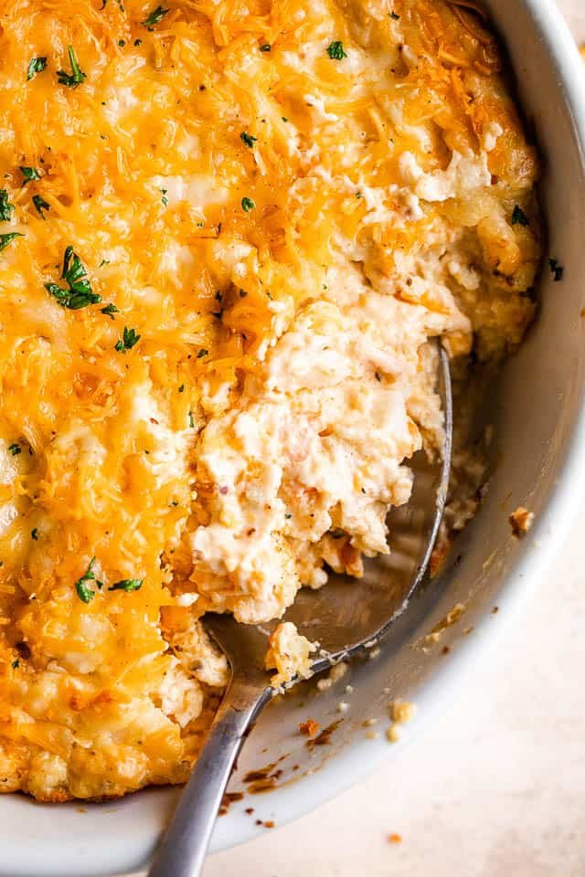 close up shot of a spoon in a baking dish with hot crab dip