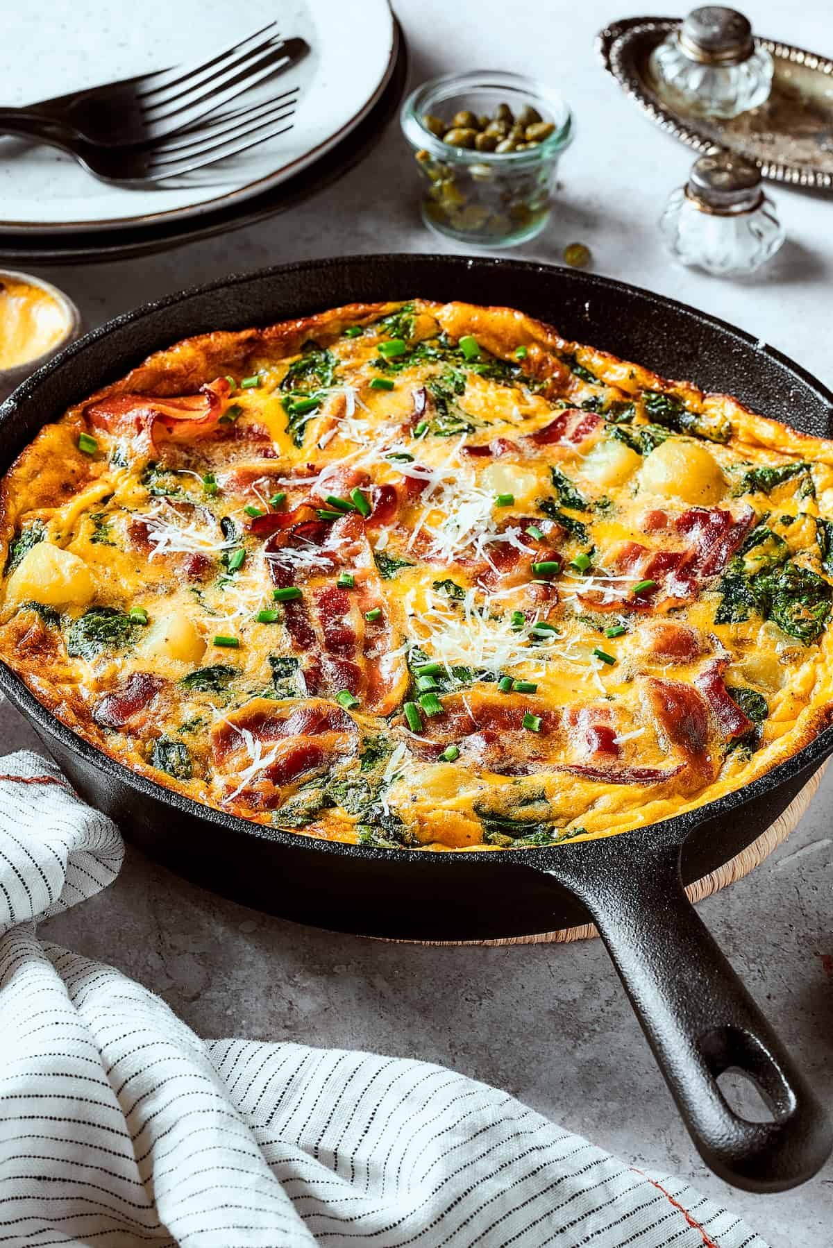A cast-iron skillet with a baked egg dish in it.