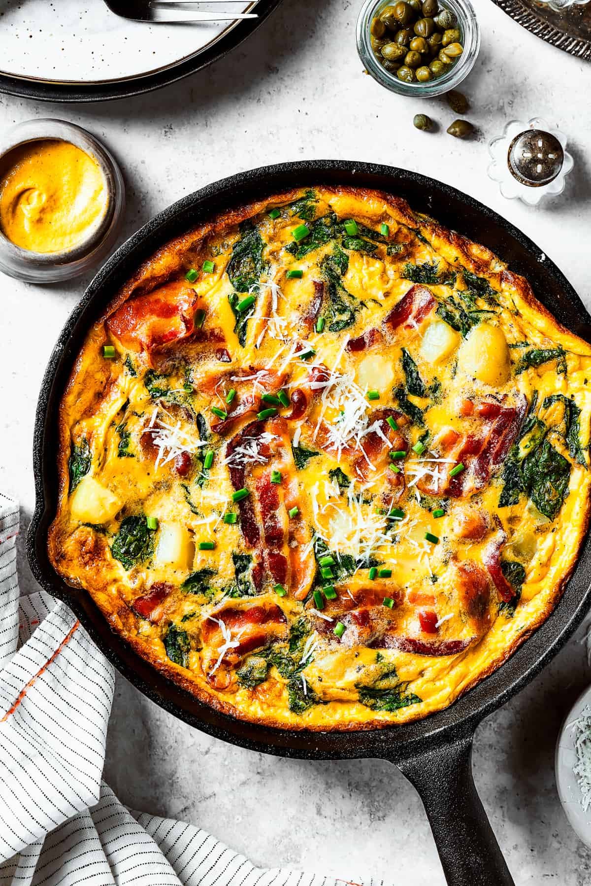overhead shot of a fully-cooked frittata in a cast-iron skillet.