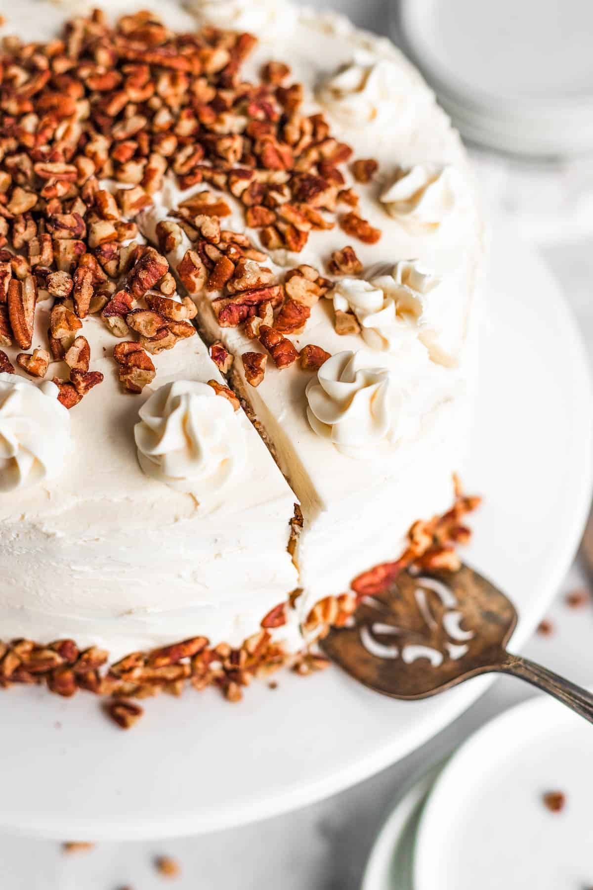 A Dessert Spatula Under a Piece of Hummingbird Cake Cut Out From the Full Cake