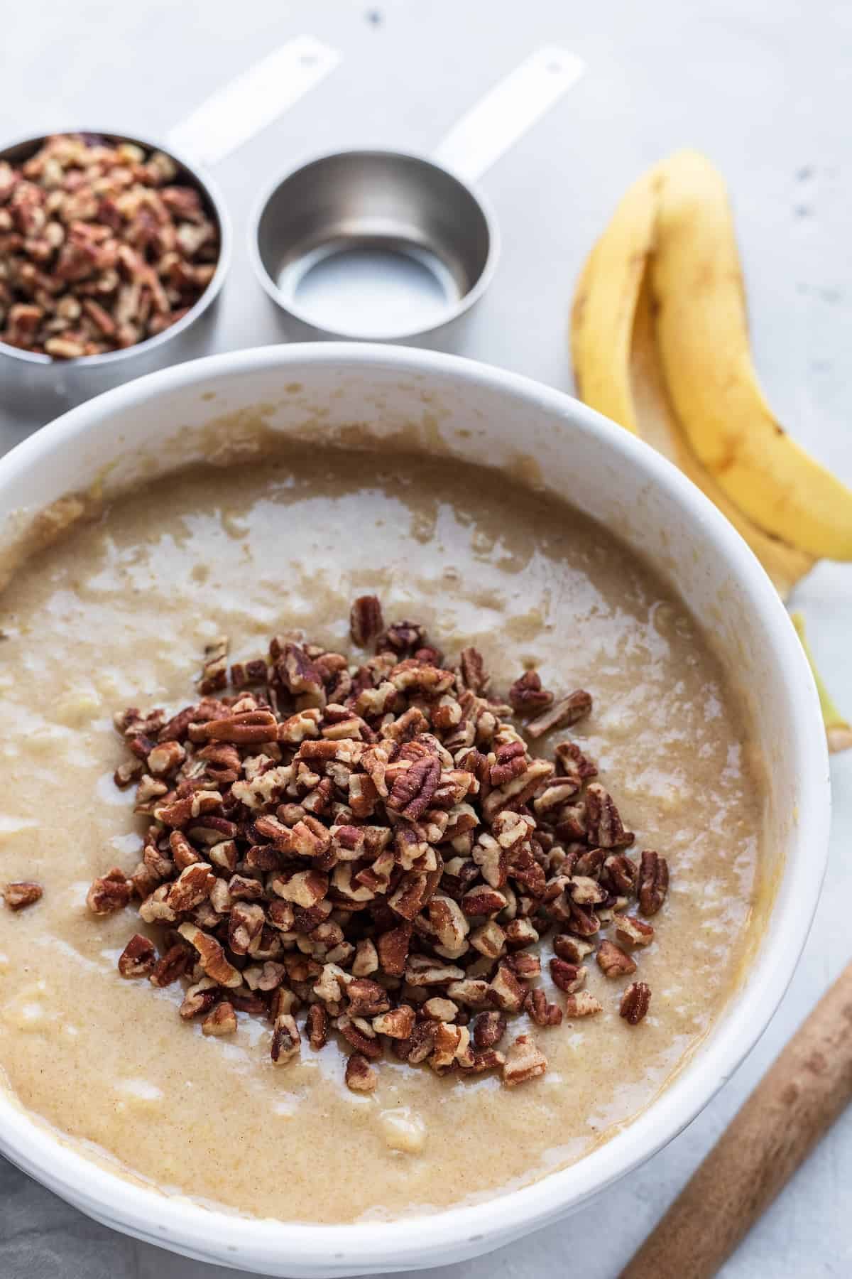 The Wet Ingredient Mixture in a Bowl with Crushed Pecans Floating on Top