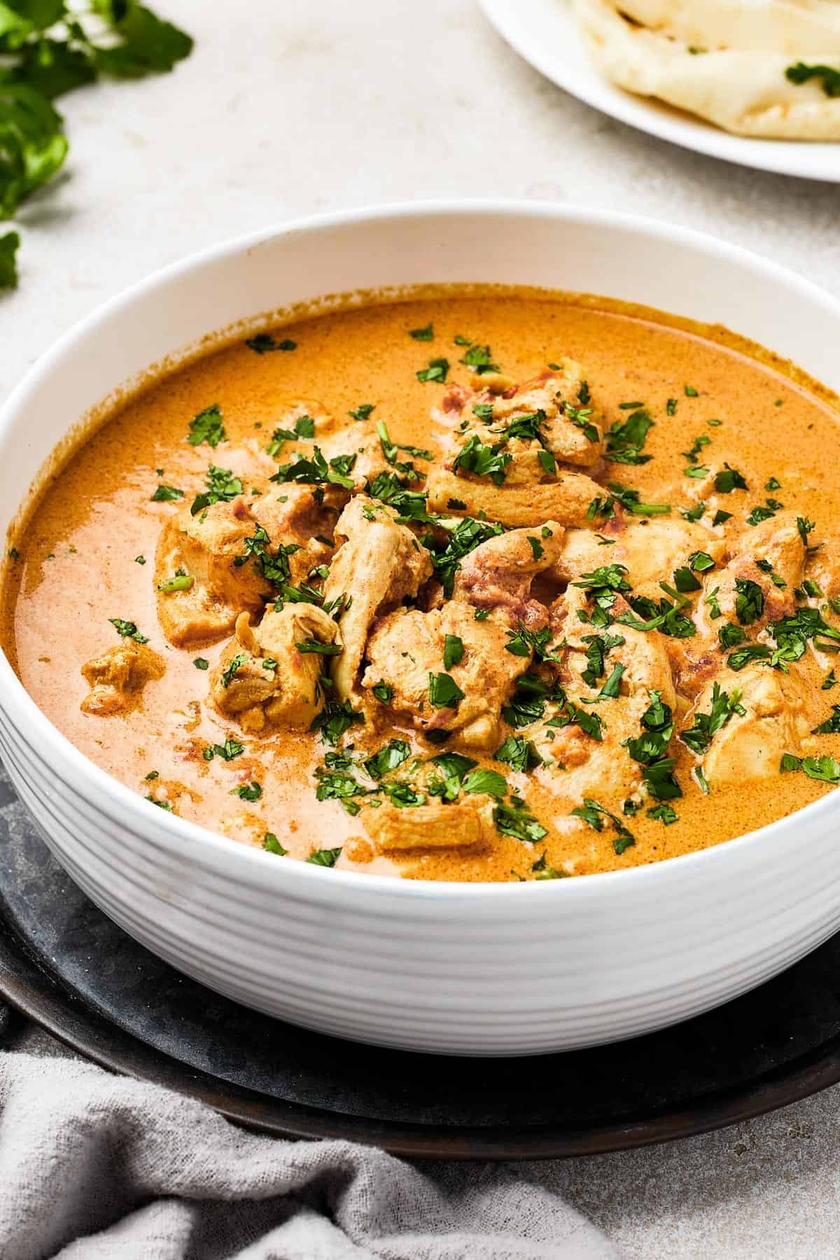 Chicken curry in a white enamel bowl.