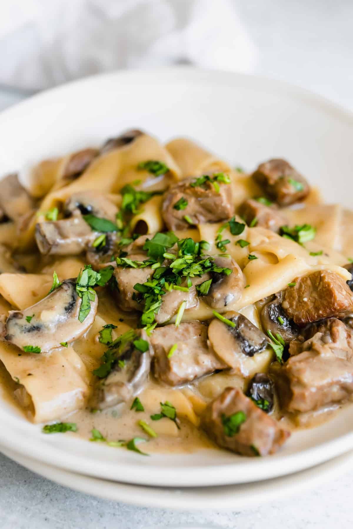 Beef Stroganoff on a White Plate with a Napkin in the Background