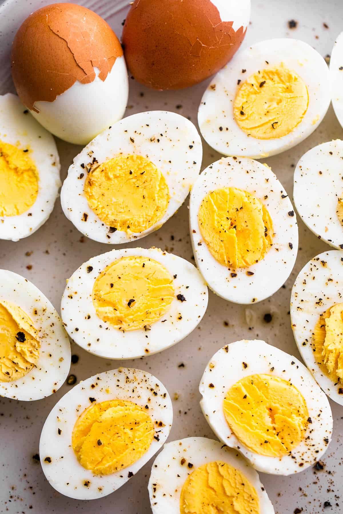halved hard boiled eggs topped with cracked black pepper