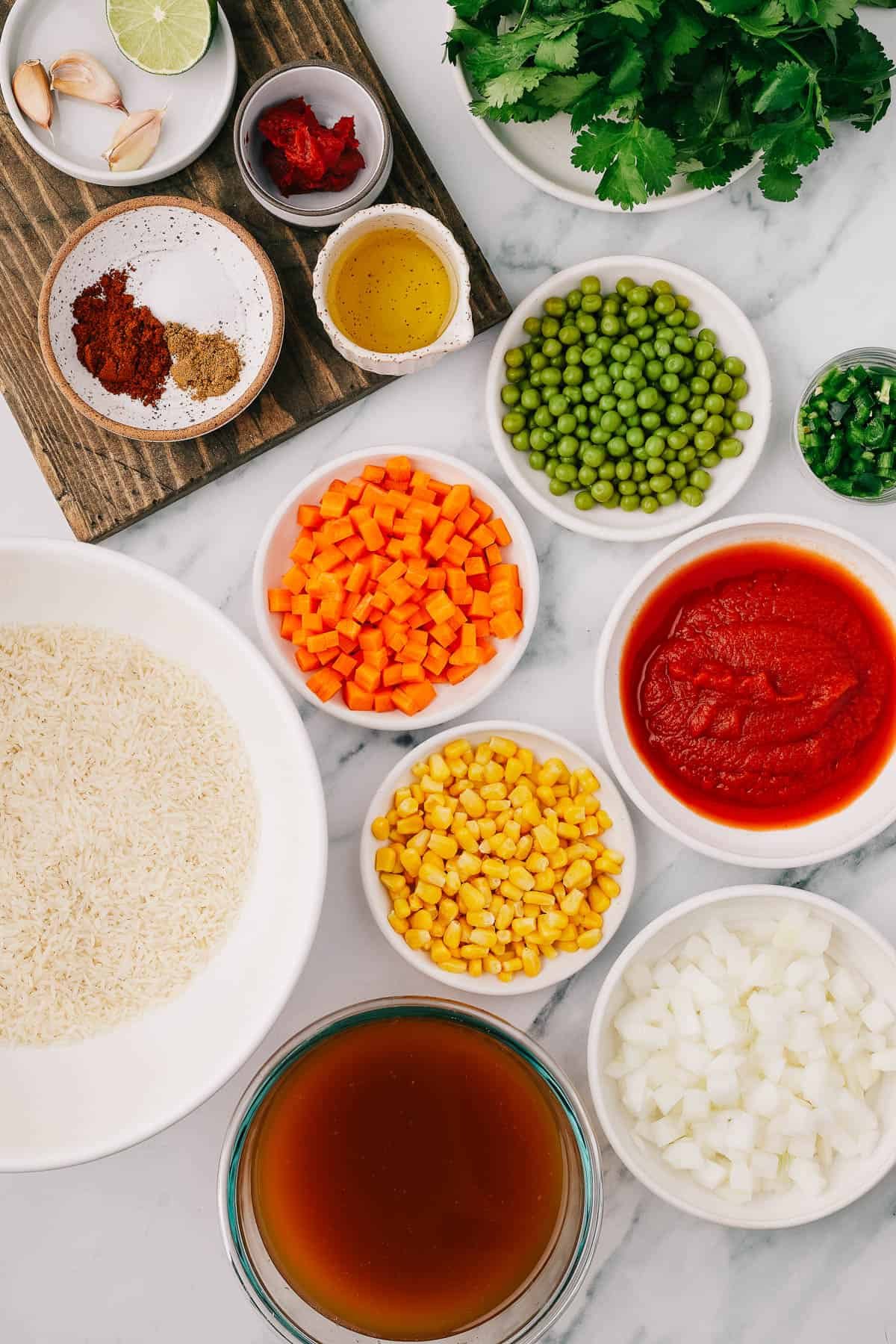 From left: garlic, lime, tomato paste, cilantro, chili powder, salt, cumin, oil, peas, jalapeno, rice, carrots, corn, tomato puree, vegetable broth, onion