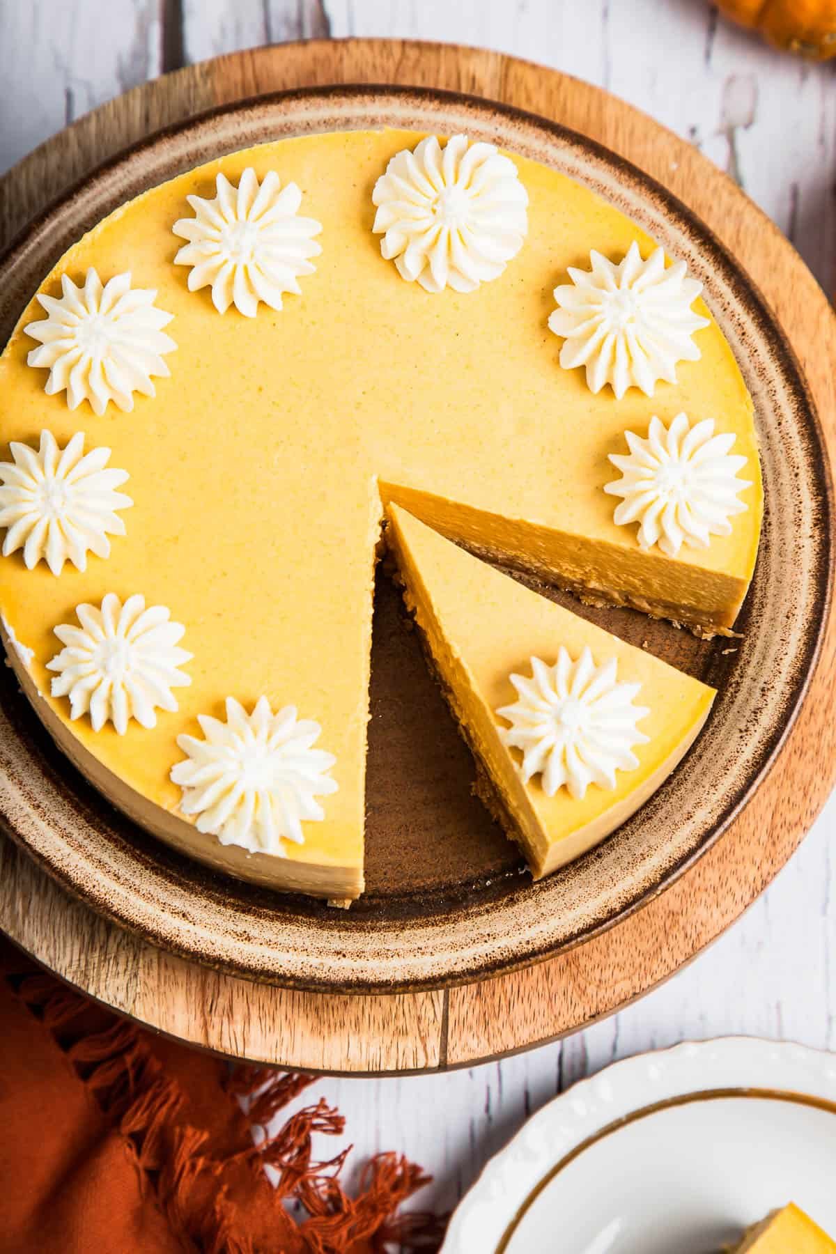 Pumpkin cheesecake decorated with whipped cream.